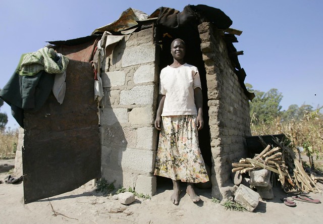 Woman poses at the front of a shack settlement in Epworth, outside the capital, Harare. /Ephraim Nsingo/IPS