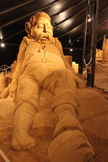 giant sitting on rock made of sand