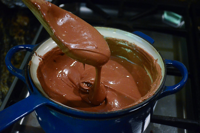 A wooden spoon stirring melted chocolate.