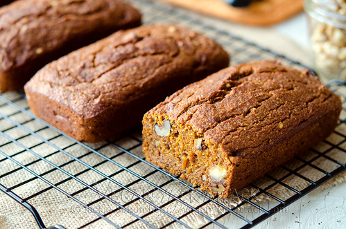 three small pumpkin bread loaves on a cooling rack