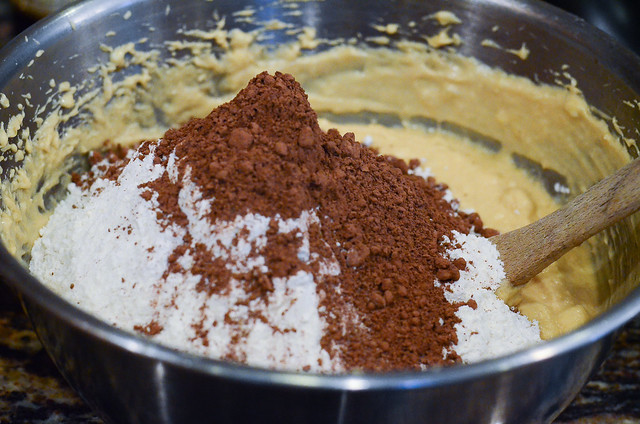 The dry ingredients are added to the wet ingredients in the mixing bowl.