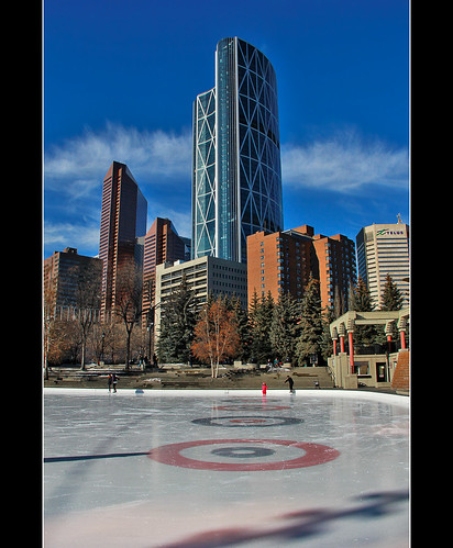trees light shadow sky people urban calgary ice nature architecture clouds canon buildings downtown afternoon skyscrapers theatre skating icerink skaters historic rings olympicplaza davidsmith thebow calgaryalbertacanada eos60d suncortowers