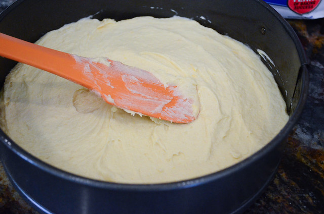 A spatula smoothing out the batter inside a springform pan.