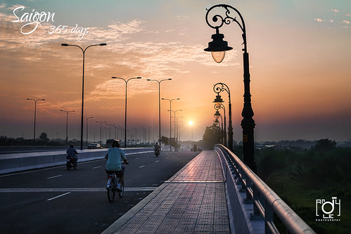 road city travel 2 people urban sun reflection tower andy water skyline night sunrise canon buildings river hotel hall asia vietnamese chaos district young culture days vietnam explore le chi ho frontpage minh saigon committee sunflare