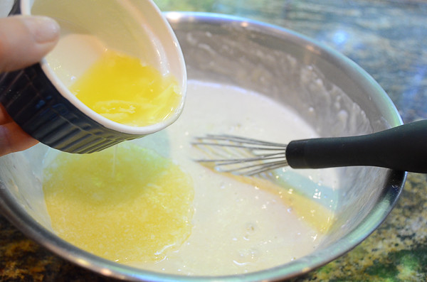 Melted butter being poured into the pancake mixture.