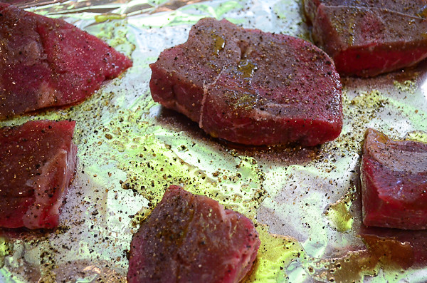 Steaks that have been seasoned with salt and pepper.