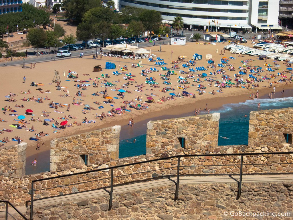 A view of the beach through crenellations in the old wall