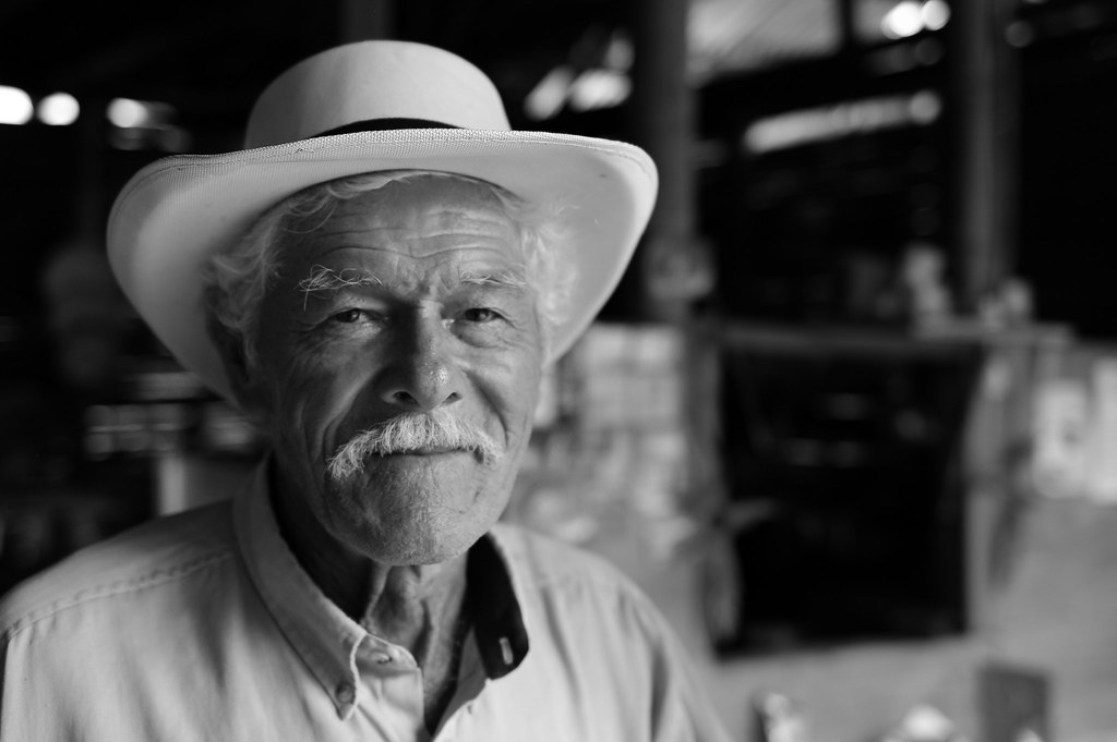 Un señor de alta de edad con sombrero mirando a la camará