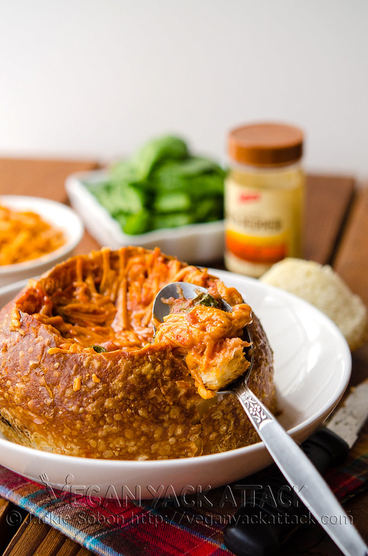 A comforting meal of tomato spinach soup in a toasted sourdough bowl, topped with melted cheddar shreds; AKA the Tomato Spinach Grilled Cheese Bread Bowl!