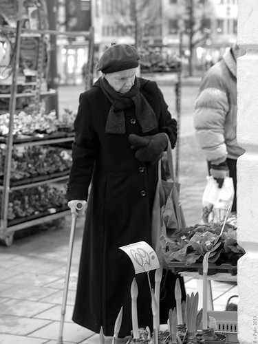 street old flowers winter blackandwhite bw flower cane lady scarf shopping looking pentax sweden coat beret k5 örebro stortorget pentaxsmcfa50mmf14 sweron 201301086008