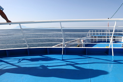 blue shadow sea summer sky white man travelling horizontal ferry outdoors island person one boat view arm horizon tourist greece kefallonia