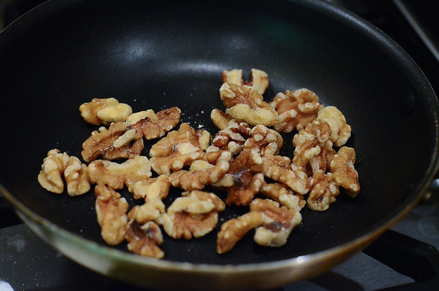 Walnuts toasting in a pan.