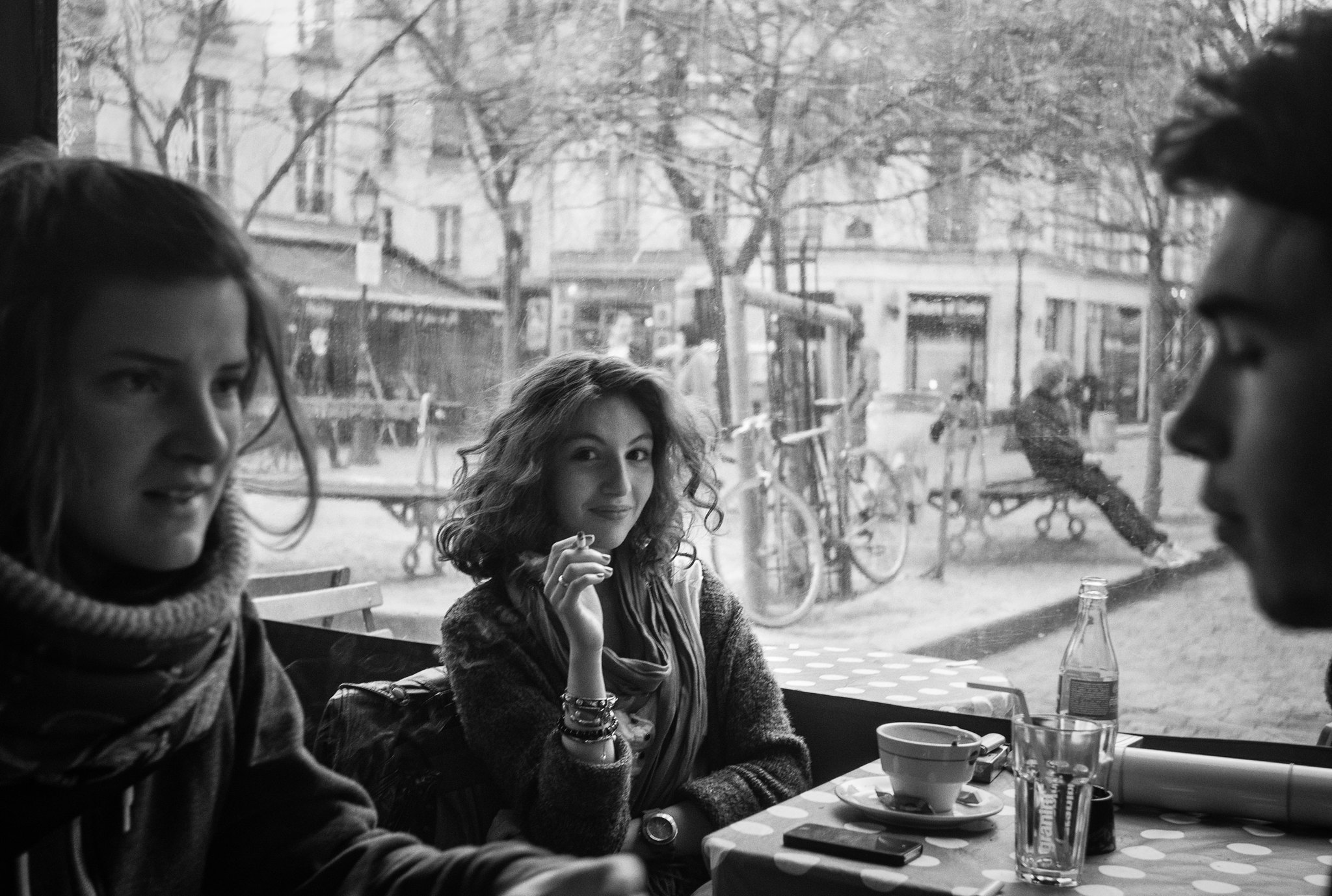 Candid shot of a French girl enjoying a cigarette in a Paris café ...