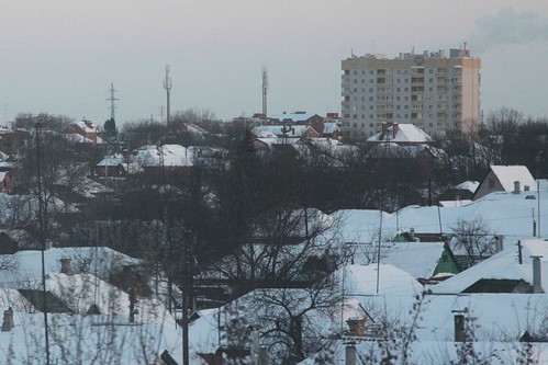 Soviet-era apartment block towers over snow covered houses in Таганрог (Taganrog)