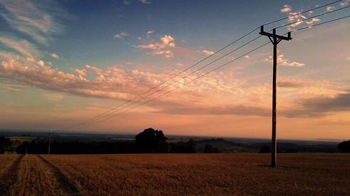 sky orange field clouds power tracks pole powerlines telegraphpole