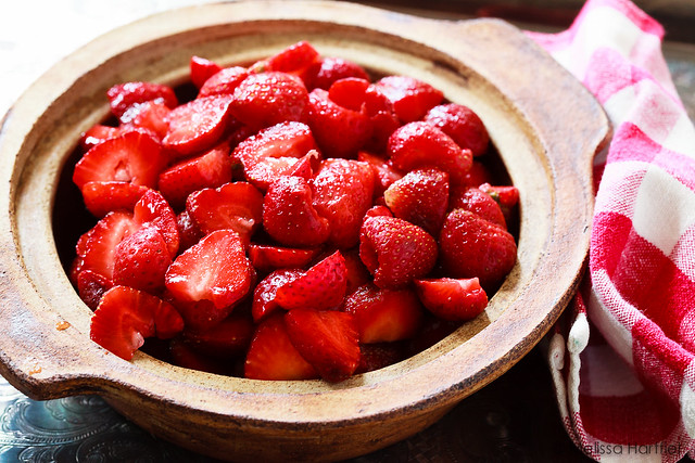 a ceramic bowl full of sliced strawberries