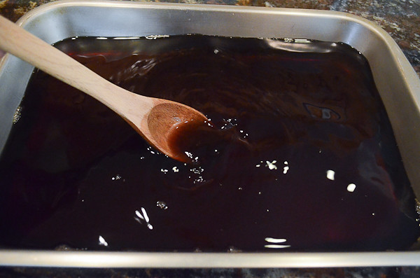 A wooden spoon stirring the sugar and coffee mixture.
