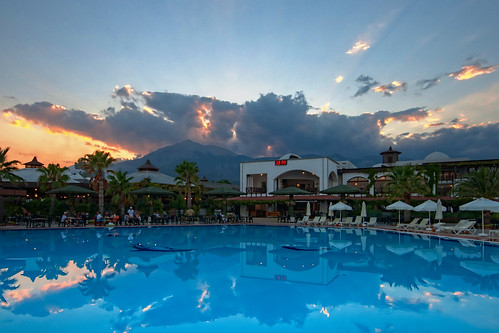 light sunset summer sky people orange sun sunlight mountain mountains tourism water pool beauty architecture clouds facade swimming umbrella outdoors hotel evening exterior chairs dusk turquoise scenic dramatic scene tourist romance structure resort clear tables poolside relaxation luxury tranquil hdr built kemer elegance turkeyeurope mttahtali
