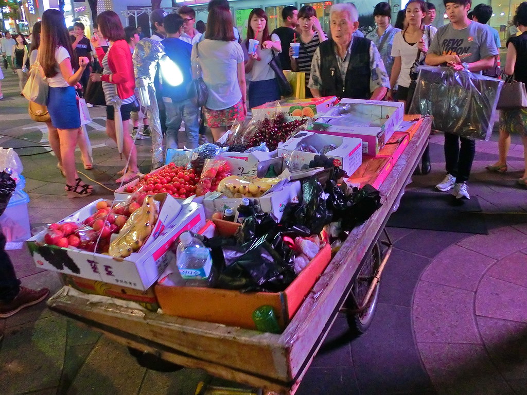 Fruit Vendor walks through Myeondong, Seoul, South Korea 