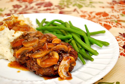 Salisbury Steak with Mushroom Gravy on a plate with mashed potatoes and green beans