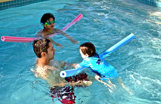 dad and two kids spending time on a pool