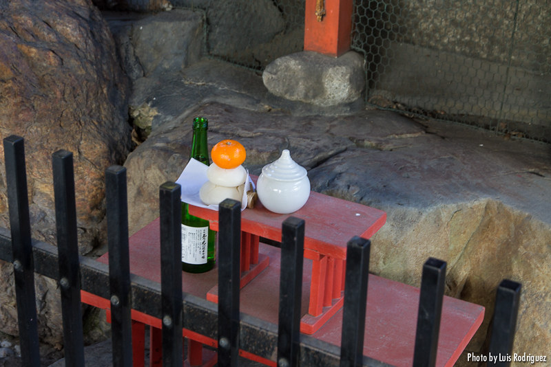 Detalle de un kagamimochi en un santuario con ofrenda de sake