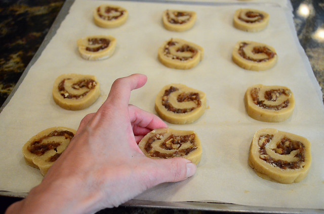 The slices of cookie dough being arranged on a parchment lined cookie sheet.
