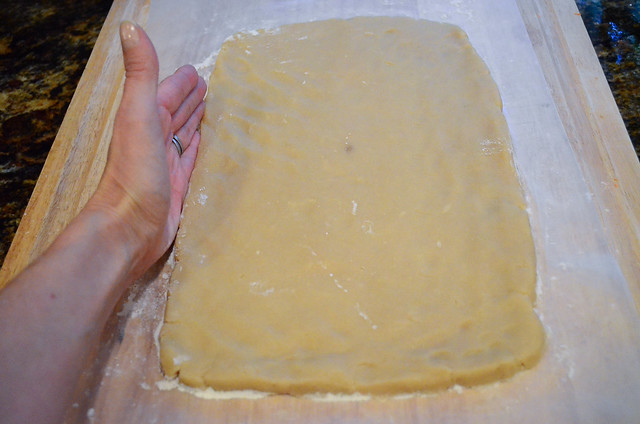 A hand forming the edge of the cookie dough.
