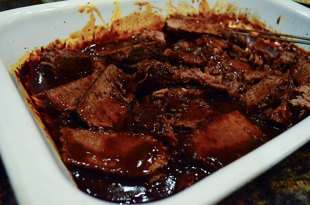 The sliced brisket is added back into the pan of sauce.