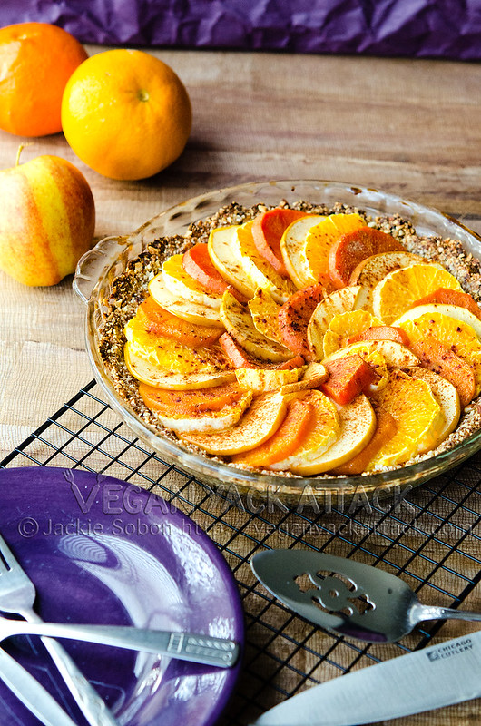 Layered fruit tart with gluten-free crust in a glass pie dish on a cooling rack
