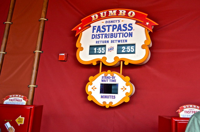 disney fastpass sign haging in a red wall