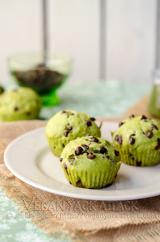Three green-hued, chocolate chip cupcakes on a plate