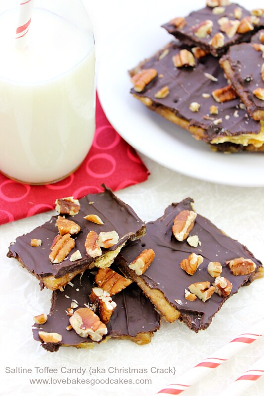 Saltine Toffee Candy stacked on a white plate with a glass of milk.