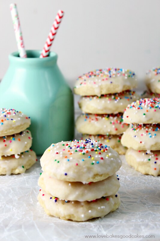 Italian Ricotta Cookies stacked up with a blue bottle.