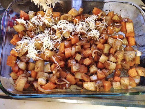 sprinkling cheese on roasted potatoes and butternut squash
