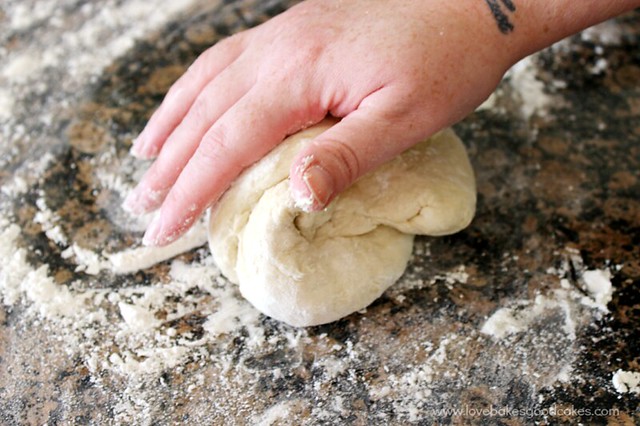 Dough being kneaded on a counter top surface.