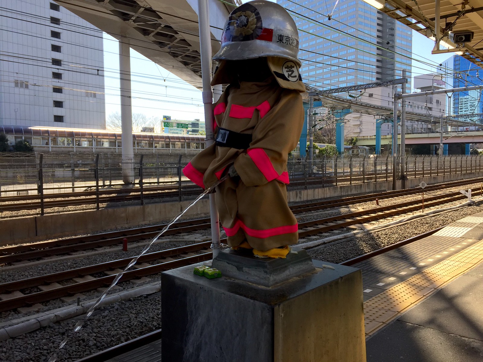 Peeing Boy Statue dressed up as a fireman at JR Hamamatsucho Station