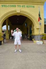 Ryan Janek Wolowski, waving hello from the Welcome to St. Kitts, arch on the Island capital city of Basseterre in the country of Saint Kitts and Nevis