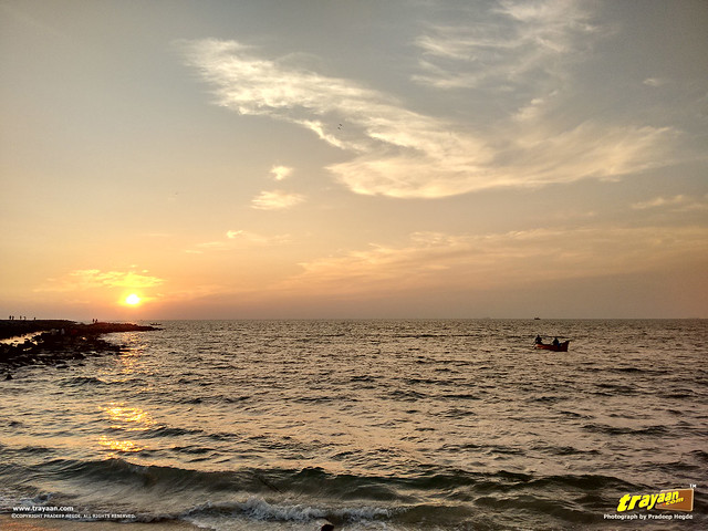 Fishermen on their boat, returning at sunset on an evening in Panambur Beach, Mangalore, Mangaluru, Dakshina Kannada, Karnataka, India
