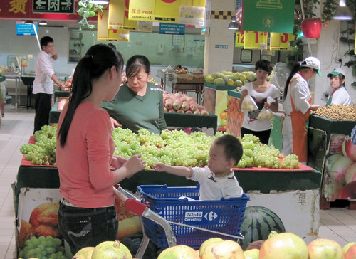 Shoppers  examine produce in Zhengzhou, central China. Photo by Fred Gale.