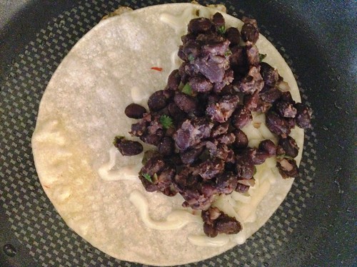 assembling crunchy black bean tacos in the pan