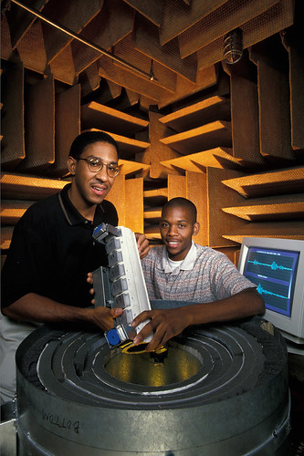 Inside a sound room, or anechoic chamber, Everett Foreman (left) and Florida A&M University student Cornelius Dunmore insert an insect detection device into another kind of portable, sound-insulated enclosure. (USDA photo by Keith Weller)
