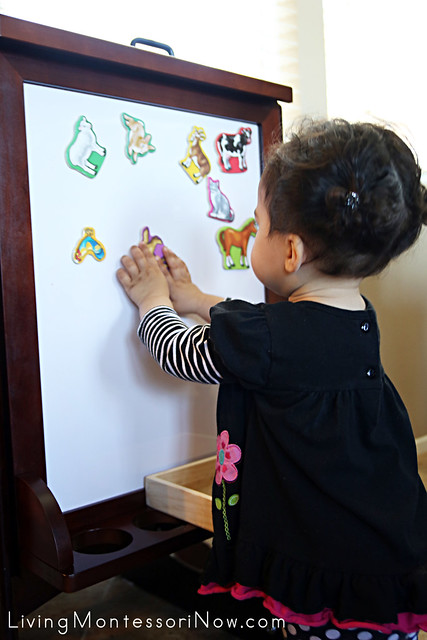Working with the Melissa & Doug Animal Magnets on the Learning Tower Easel at 15 months
