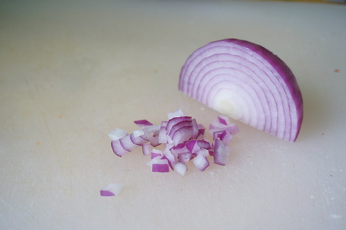 Minced red onion next to an onion quarter