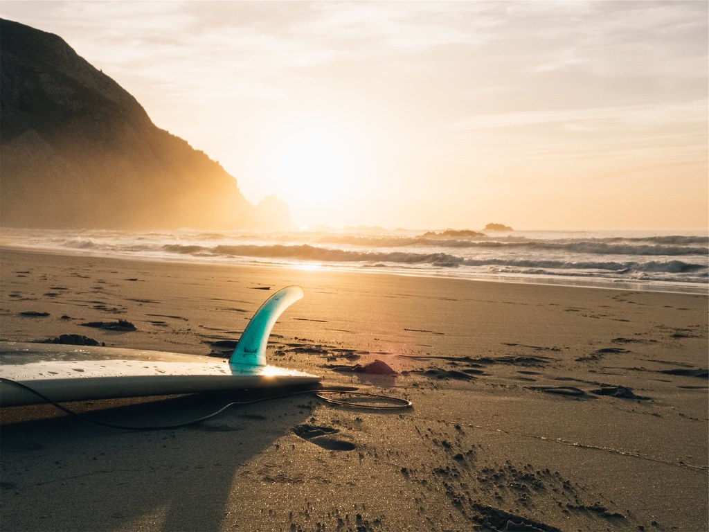 Foto gratis de una tabla de surf en la arena de la playa