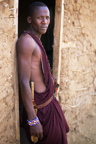 africa travel vacation portrait people man male wall architecture pose cabin day arm outdoor african traditional scenic culture photojournalism posing case clothes portraiture shanty tradition fullframe shoulder doorframe 50mmf14 reportage afrique africans hutte tunic portray traditionnal estetic photoreport photoreportage planmoyen planamericain inkajijik pleinformat shúkà