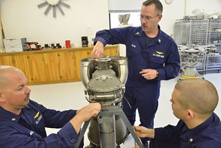 Petty Officer 1st Class Mark Petre (center), instructor at Aviation Technical Training Center in Elizabeth City, N.C., (center) offers instruction to Petty Officers 3rd Class Justin Mahaffey and  Jentzen Green, both students and aviation maintenance technicians, during an AMT H-65 "C" school class at ATTC Nov. 18, 2014. Student AMTs became familiar with the MH-65 Dolphin helicopter's Turbomeca engine during the class. (U.S. Coast Guard photo by Petty Officer 3rd Class Nate Littlejohn)