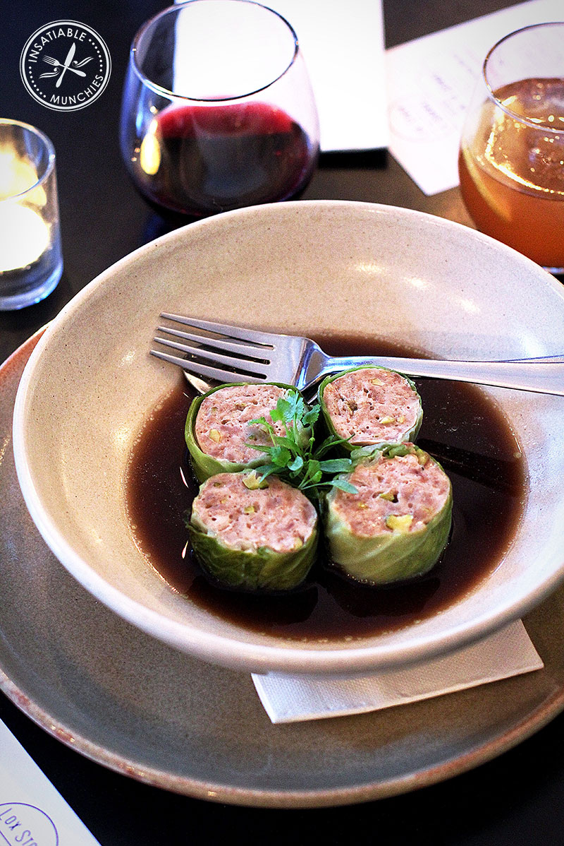 Duck and Pistachio Cabbage Rolls with Mushroom Consomme and Baby Herbs