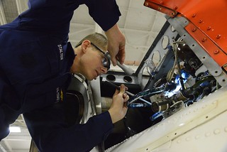 Petty Officer 3rd Class Kyle Stalter, an aviation maintenance technician at Air Station Elizabeth City in North Carolina, performs a safety check of fire extinguishing system components on an MH-60 Jayhawk helicopter at the air station Nov. 14, 2014. AMTs like Stalter are responsible for inspecting, servicing, maintaining, troubleshooting and repairing aircraft engines, auxiliary power units, propellers, rotor systems, power train systems and many other things in the world of Coast Guard aviation. (U.S. Coast Guard photo by Petty Officer 3rd Class Nate Littlejohn)