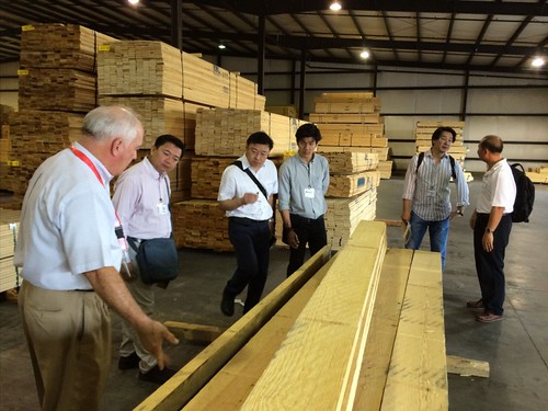A delegation of Thai lumber company executives (including Opas Panitchewakul, Pracha Thawornjira, Jaroonsak Cheewatammanon, Khomwit Boonthamrongkit and Wasant Sonchaiwanich) tours the Mauvila Timber distribution warehouse in Loxly, Ala., with Lane Merchant (left), the company’s general manager.